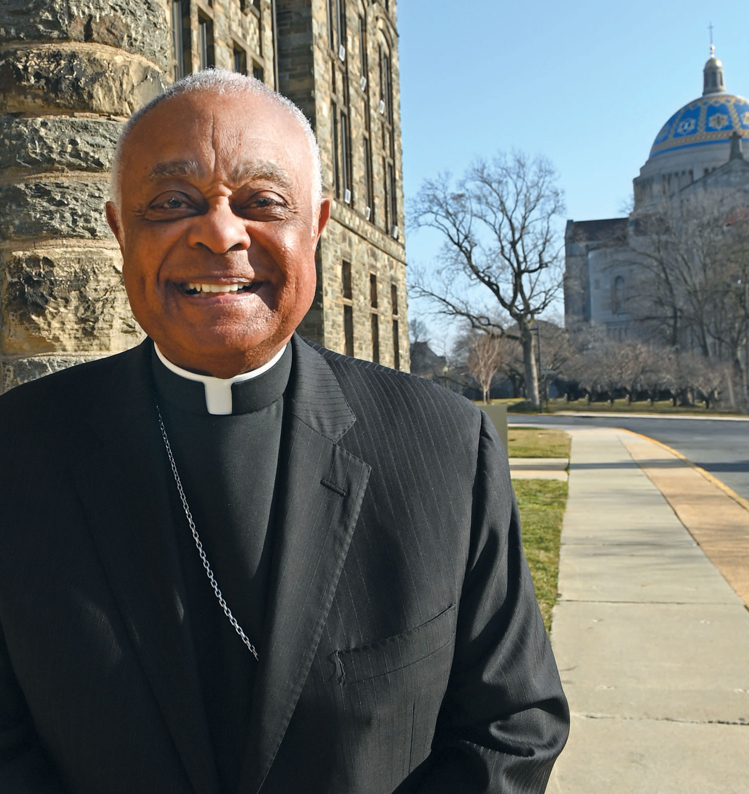 Archbishop Wilton Gregory in front of Caldwell Hall with the Basilica of the National Shrine of the Immaculate Conception in the background