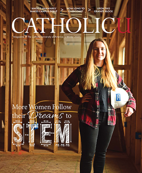 Cover of CatholicU Magazine showing a female alumna standing at a construction site holding a helmet