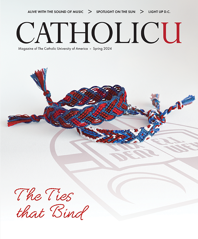 Cover of CatholicU Magazine. On it, woven bracelets made of blue and red thread.