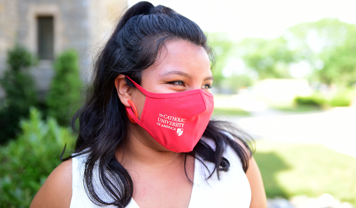 Female student wearing a red Catholic University of America mask