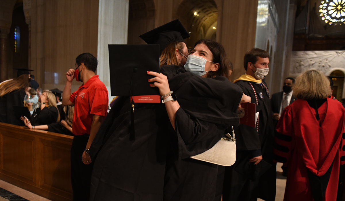 Recent graduates embrace in celebration