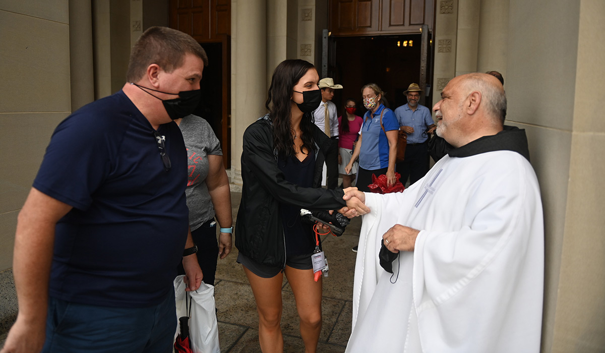 University chaplain shakes hands with student