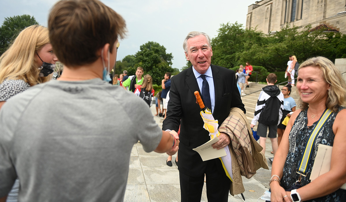 President John Garvey shakes hands with a student after Mass