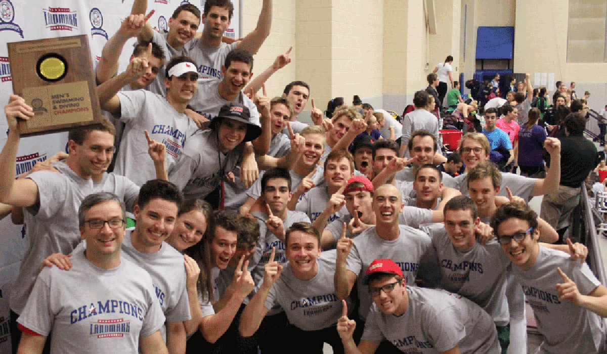 Men's swimming team celebrating with championship trophy