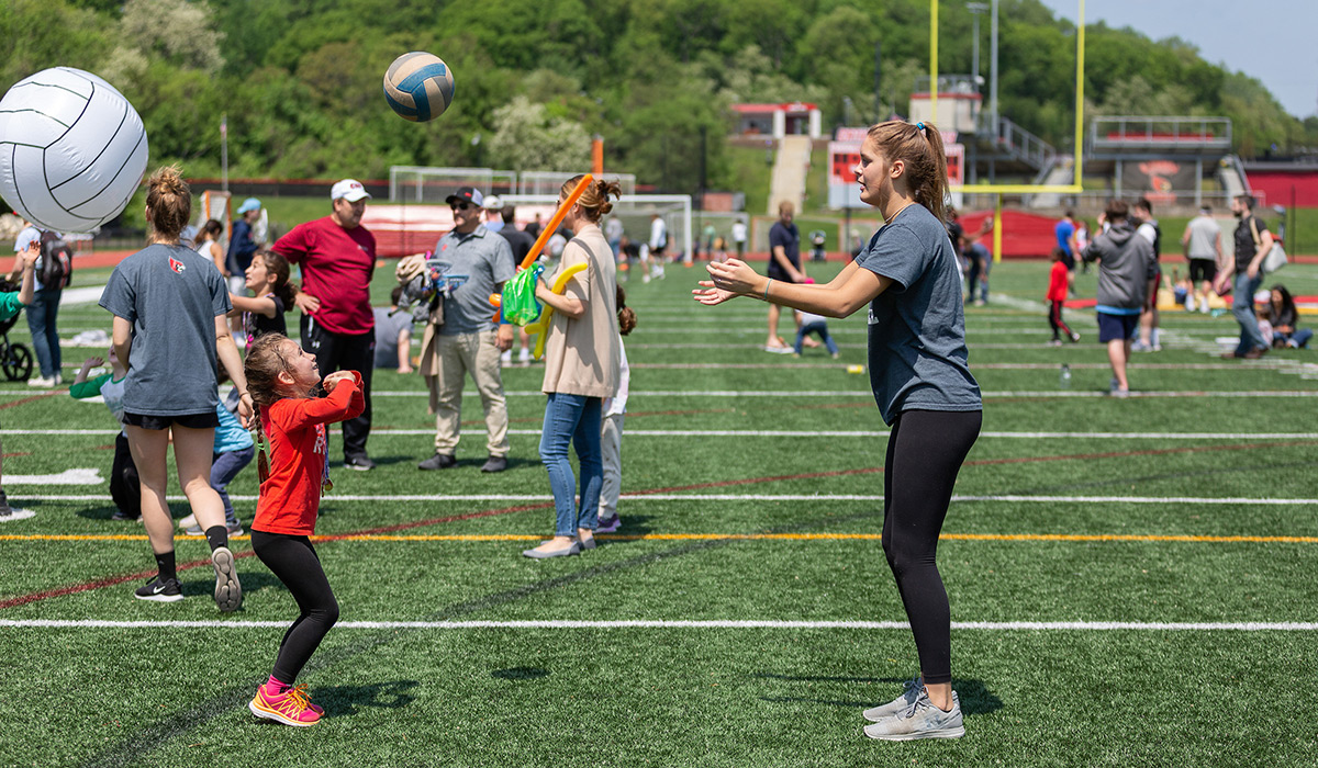 Student-athlete playing with a kid during the University's Field Day