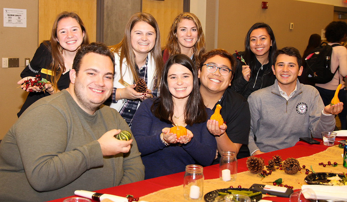 Students smiling and holding gourds