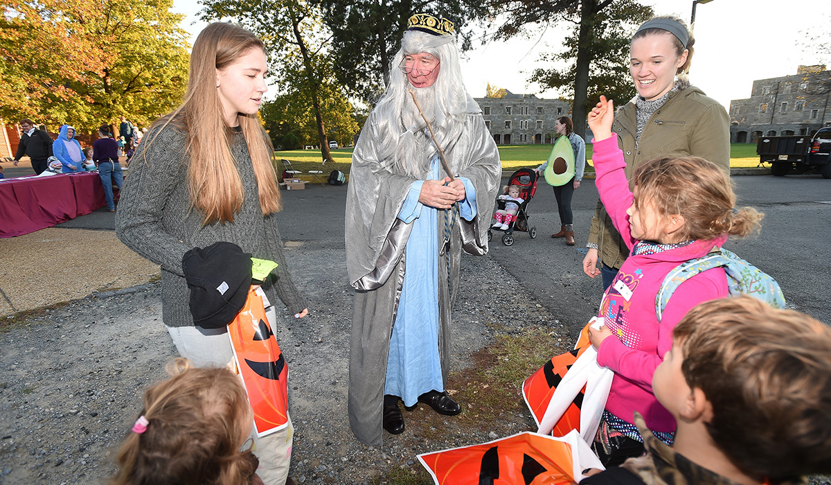 Students handing out candy to neighborhood children on Halloween 