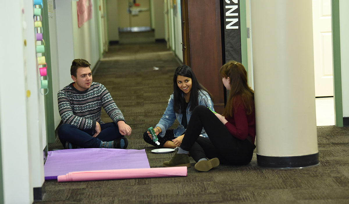 Students working on a residence hall poster