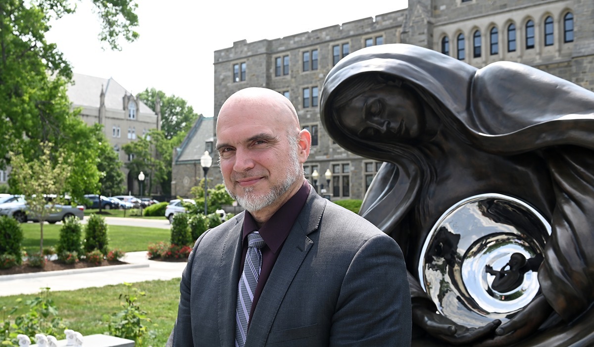 Timothy Schmalz stands with his sculpture of the National Life Monument following its unveiling at the Theological College May 17. 