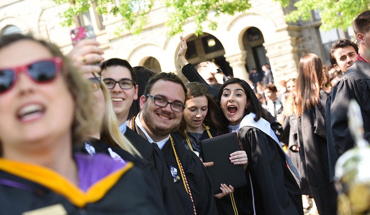 Students taking selfies at Commencement