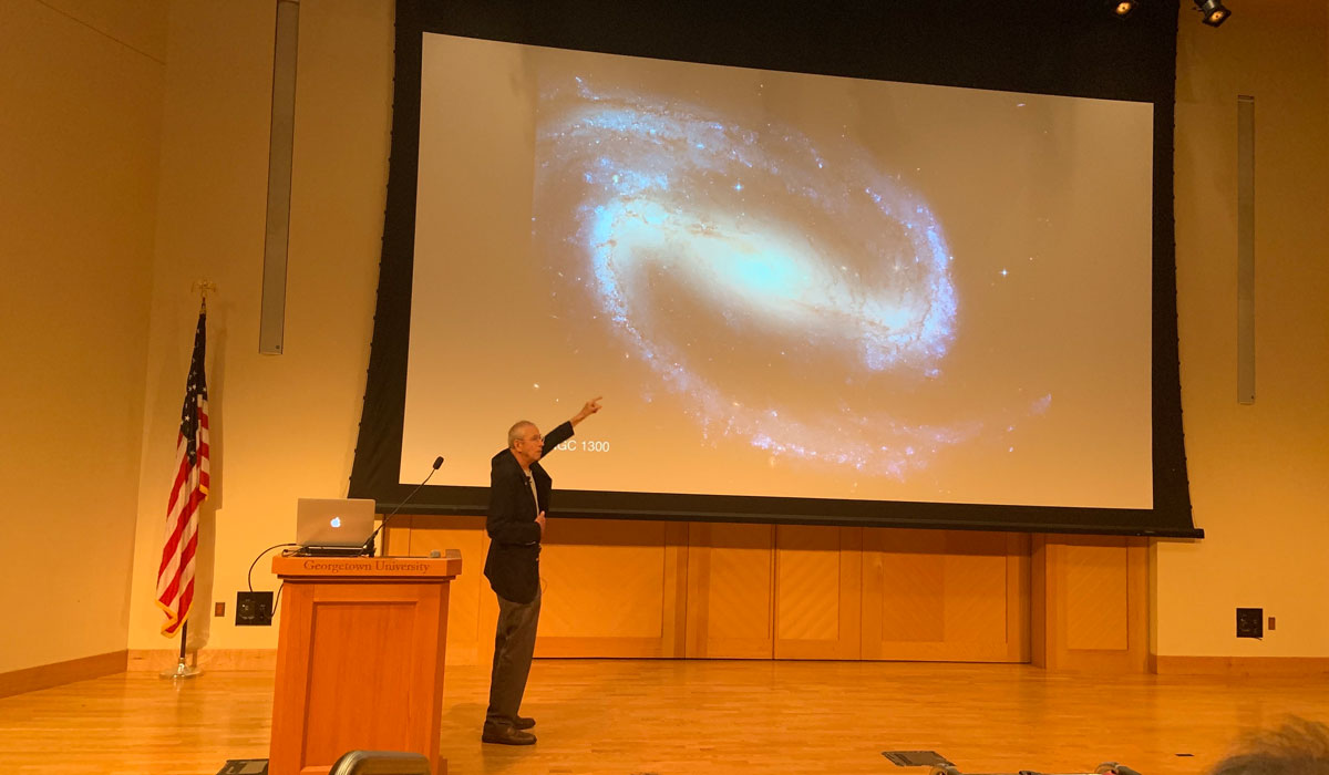 James Peebles pointing to an image of a galaxy