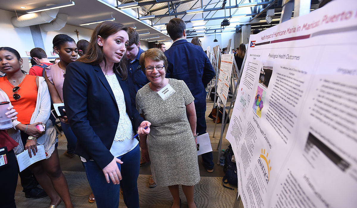 Female student presents her poster to Nursing Dean Pat McMullen