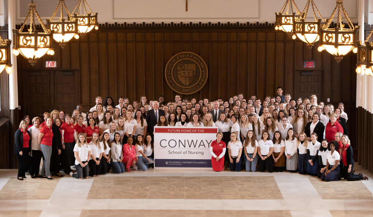 Group photo of Bill Conway with Nursing Dean Pat McMullen and nursing school students