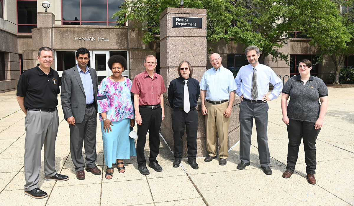 Members of PHaSER standing in front of Physics building