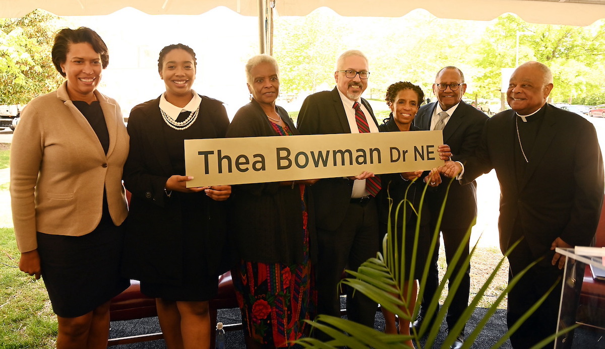 Mayor Muriel Bowser, Provost Aaron Dominguez, Cardinal Wilton Gregory, and some members of the university community pose with the street sign for Thea Bowman drive