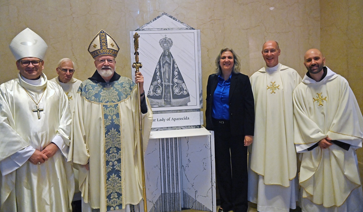 Duilia de Mello and the mass's concelebrants pose next to an image of Our Lady of Aparecida where the statue will stand in the basilica