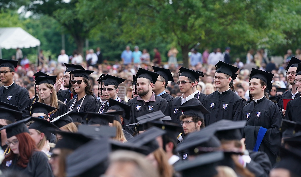 Students listen to someone speak at their Commencement ceremony