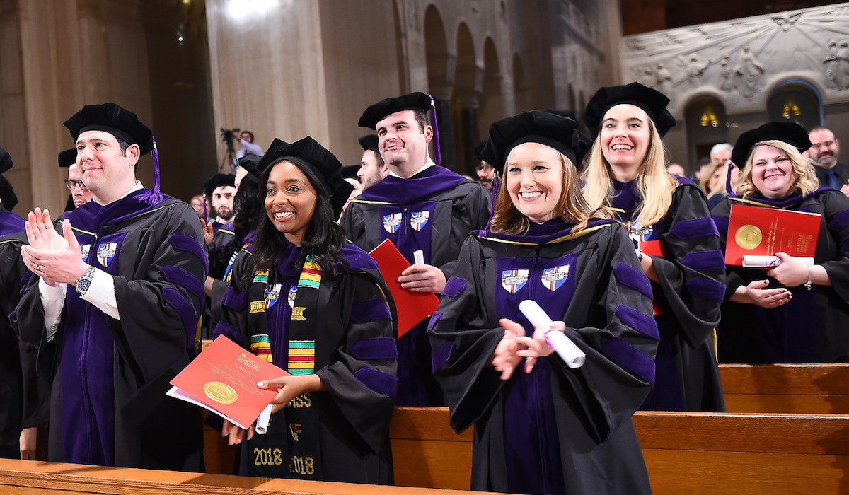 CUA Law school graduates clapping during part of their commencement ceremony