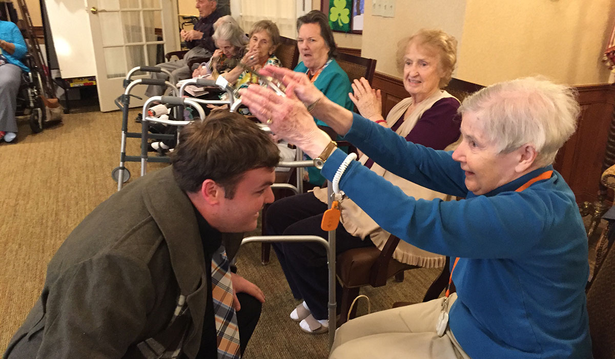 Kevin Boudreau, M.F.A. acting candidate who plays Malcolm in Macbeth, is crowned by a resident of Sunrise Assisted Living