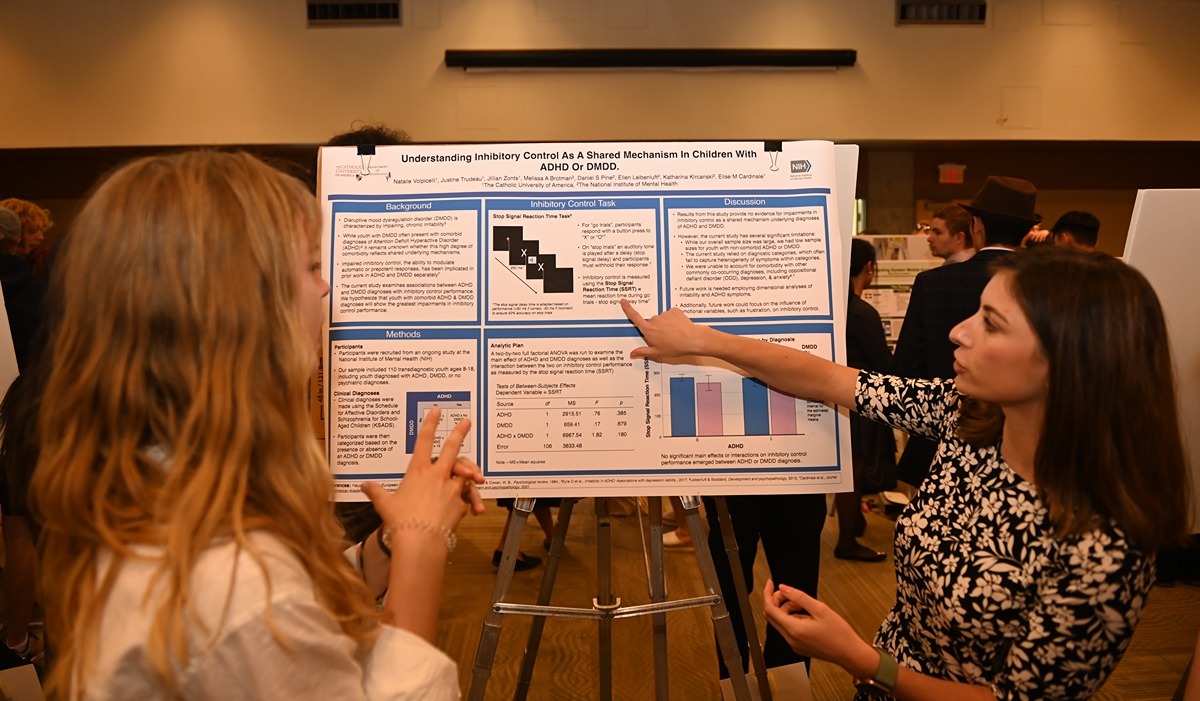 A student shares the results of her research during University Research Day 2023 poster presentation session in the Edward J. Pryzbyla Center’s Great Room. (Catholic University/Patrick G. Ryan)